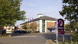 A hotel entrance with a prominent Premier Inn sign, a parking lot, and a building with large windows and a brick facade. - Premier Inn Reading - Caversham Bridge (Reading)