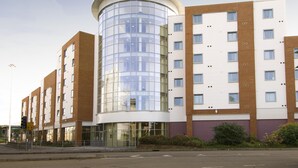 A modern hotel with a curved glass facade, multiple floors, and a brick exterior. - Premier Inn Reading Central (Reading)