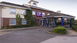 A Premier Inn hotel with a brick facade, a covered entrance, and a clear sky. - Premier Inn Rugby North - Newbold (Rugby)