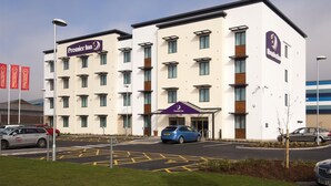 A multi-story hotel with a prominent 'Premier Inn' sign, a parking lot, and a clear sky. - Premier Inn Widnes (Widnes)