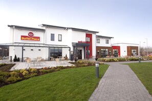 En moderne bygning med et skilt, der viser 'Buffet Place', og et velkomstskilt.