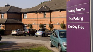 En skylt för Premier Inn med en lista över bekvämligheter: mötesrum, gratis parkering och barn bor gratis.