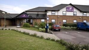 A Premier Inn hotel with a brick facade, a parking area, and a blue van parked outside. - Premier Inn Hatfield (Hatfield)