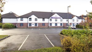 Un edificio con un letrero de 'Premier Inn' y un estacionamiento al frente.