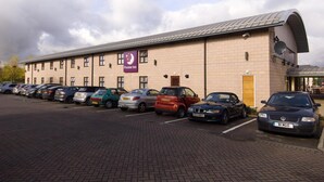 A hotel with a parking lot, a prominent Premier Inn sign, and a brick facade. - Premier Inn Manchester - Cheadle (Cheadle)