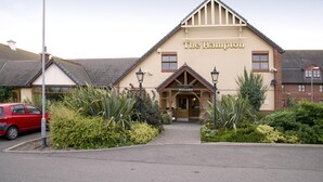 Un immeuble avec une enseigne indiquant « The Hampton » et une entrée accueillante.
