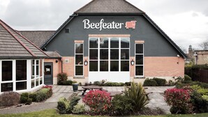 Een gebouw met een bord waarop 'Beefeater' staat en een groot raam.