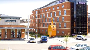 A hotel with a prominent yellow sculpture, a modern glass building, and a sign for 'The Bluebrick' hotel. - Premier Inn Wolverhampton City Centre (Wolverhampton)