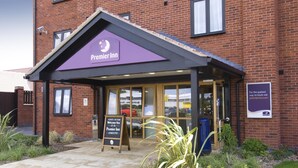 L’entrée d’un hôtel Premier Inn, avec une façade en briques, un espace d’entrée abrité et une enseigne.