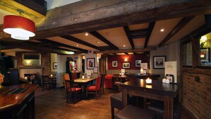 A restaurant with wooden beams, brick walls, and a bar area. - Premier Inn Swindon North (Swindon)