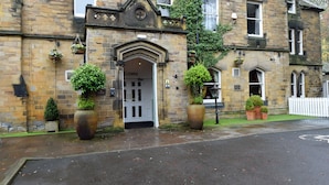 A historic building with a stone facade, a prominent entrance with a 'Welcome' sign, and the name 'HOLTFIELD ARMS' displayed above. - Holmfield Arms By Greene King Inns (Wakefield)