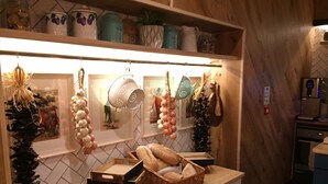 Una cocina con encimera de madera, utensilios de cocina colgando y salpicadero de azulejos.