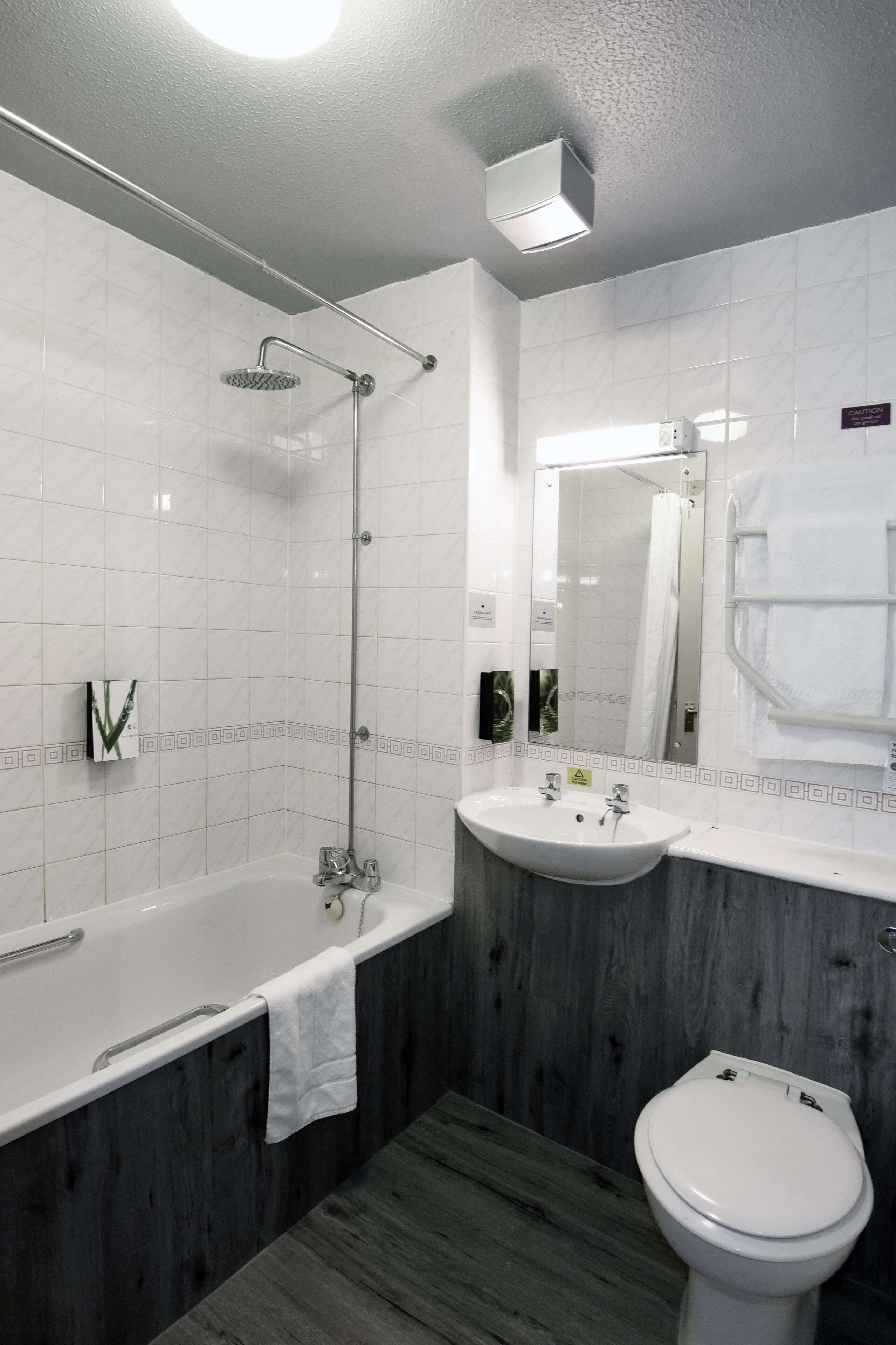 A modern bathroom with a bathtub, sink, and toilet.