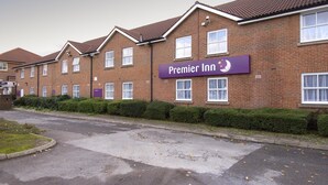 A row of brick buildings with a sign for Premier Inn. - Premier Inn Warrington - A49/M62 J9 (Warrington)