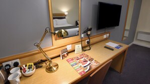 A hotel room with a desk, a mirror, a bed, a TV, and a coffee maker. - The Mount By Greene King Inns (Wigan)