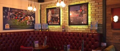 Un ristorante con panche in pelle, tavoli e lampadari.