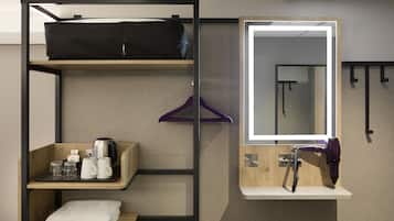 A bunk bed with a top shelf holding a bag, a shelf with a coffee maker and glasses, a mirror, and a towel on the bottom shelf.