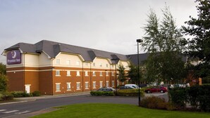 Un hotel con un cartello ben visibile, diverse finestre e un'area di parcheggio.