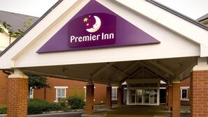 L'ingresso di un hotel Premier Inn con facciata in mattoni, una tettoia e cielo sereno.