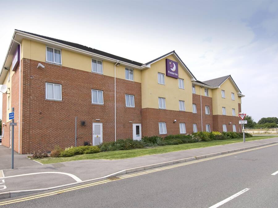 Um hotel de vários andares com fachada de tijolos, várias janelas e uma placa indicando Premier Inn.