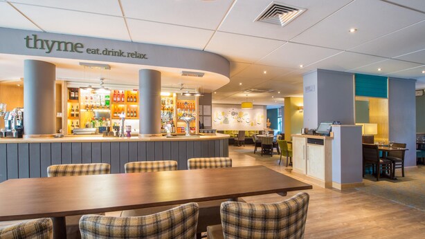 Un'area ristorante con un bar, posti a sedere e un bancone.