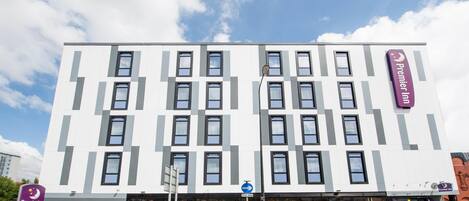 A modern hotel with a white facade, multiple windows, and a prominent Premier Inn sign.