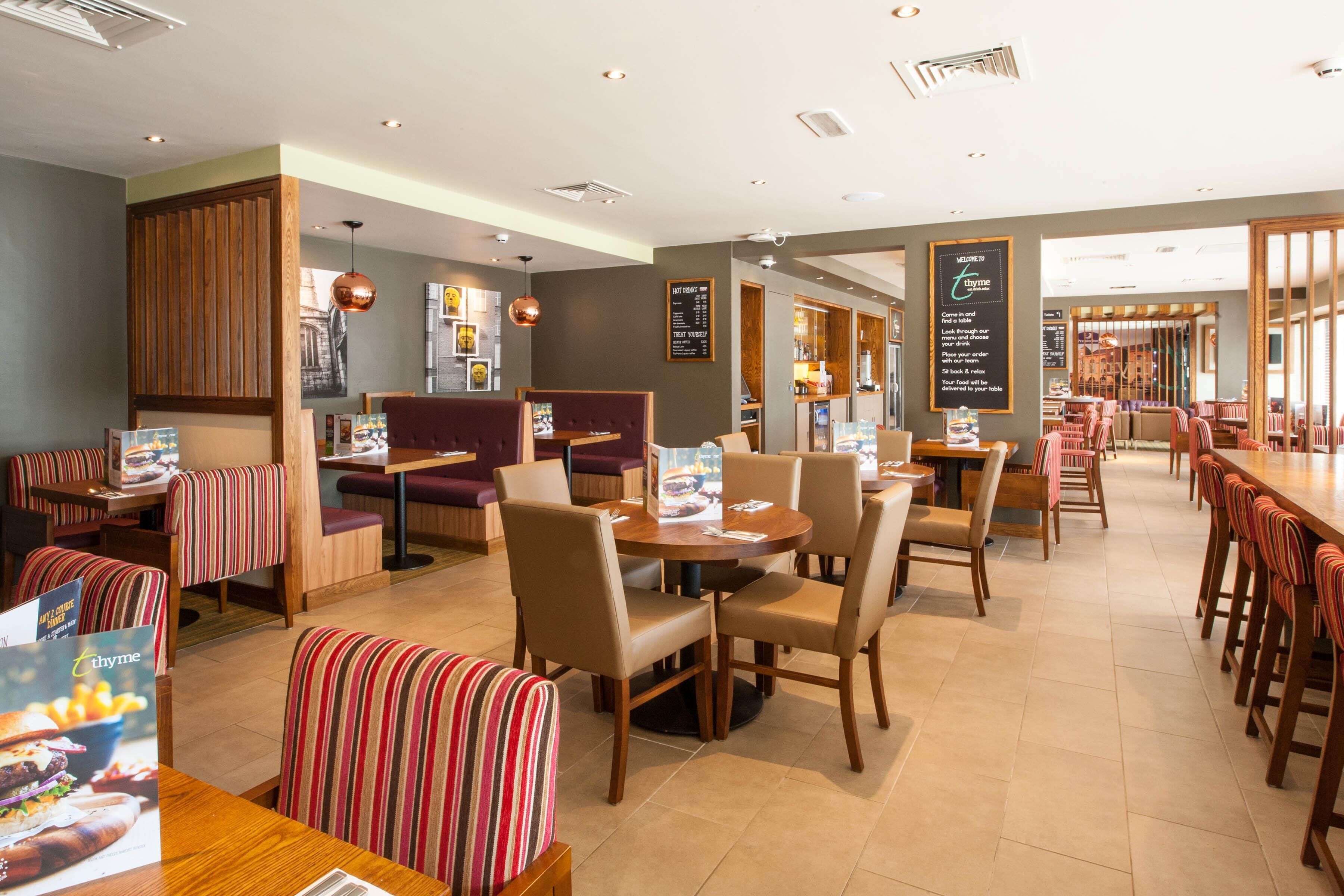 A restaurant with booths and tables, wooden accents, and menu boards.