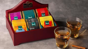 A tea display with various tea bags and two glasses of tea.