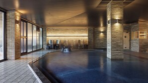 A modern indoor pool area with a sleek design, featuring a long, narrow pool, tiled flooring, and a stone wall with integrated lighting. - Grand Mercure Ise-shima Resort & Spa (Shima)