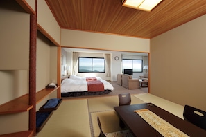 Une chambre d’hôtel équipée d’un lit, d’un bureau, d’une chaise, d’une télévision et offrant une vue sur l’extérieur.