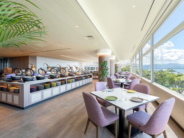 Un restaurant moderne avec un long comptoir, des chaises violettes et une vue sur l’extérieur.
