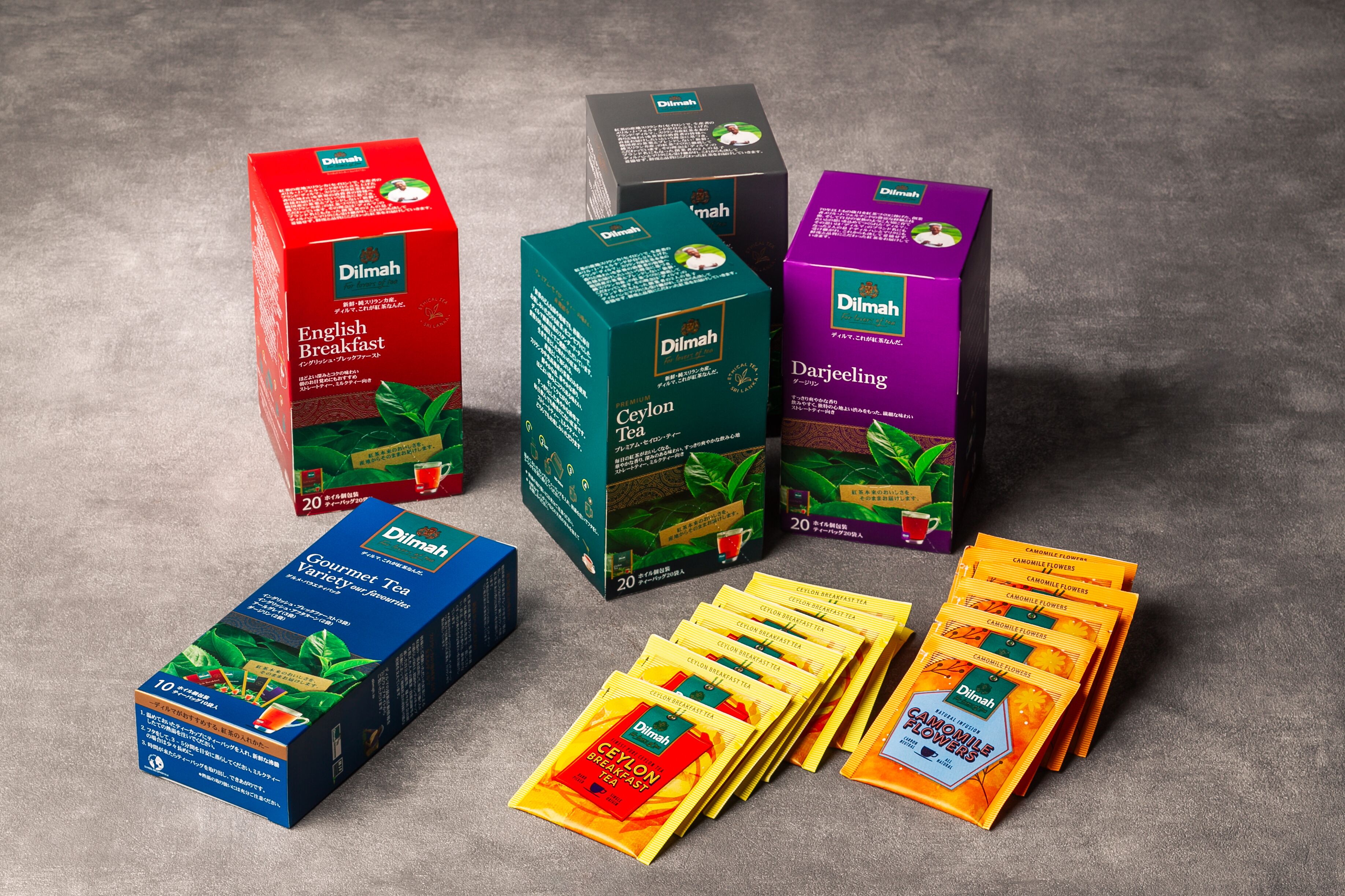 Various tea boxes and packets, including brands like Dilmah and Ceylon Tea, arranged on a surface.