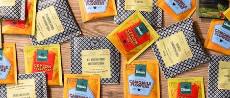 Variedad de paquetes de té y bolsitas de té esparcidos sobre una superficie de madera.
