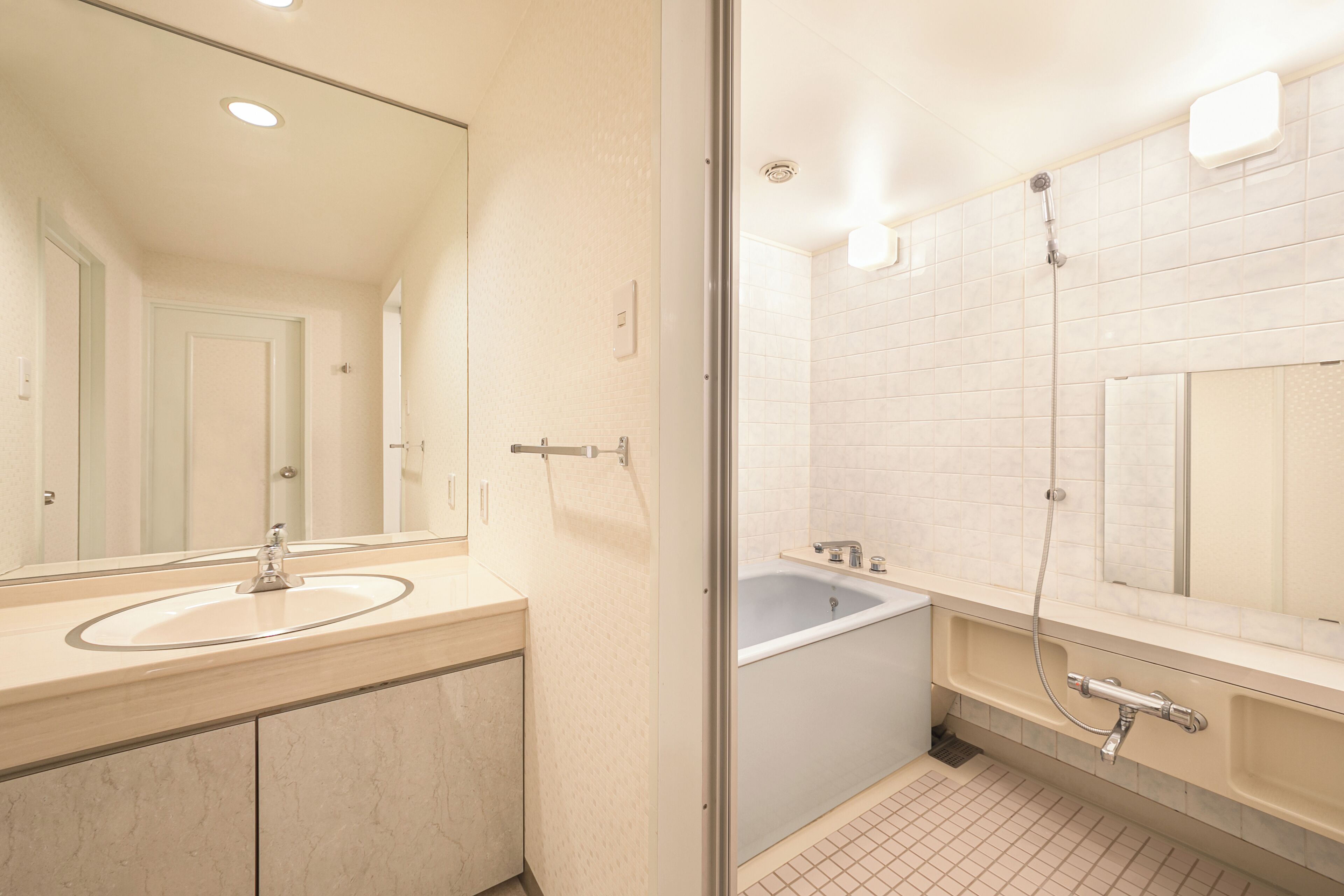 Un baño moderno con lavabo, espejo y bañera.