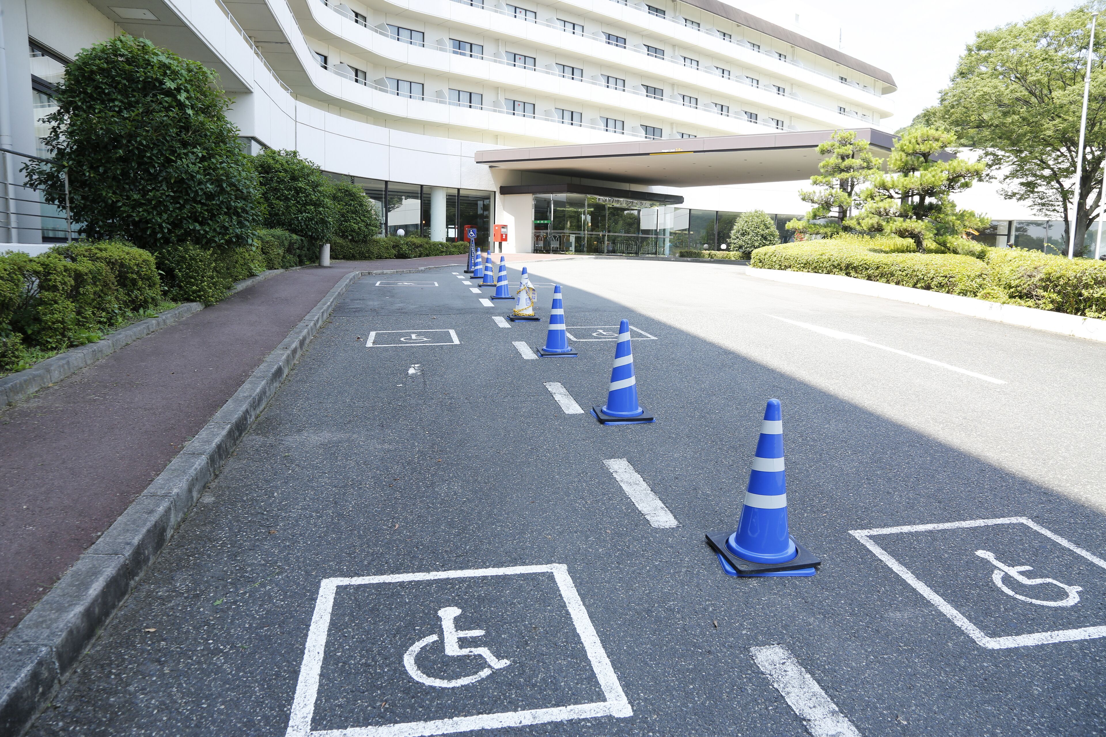 A parking area with blue traffic cones and wheelchair accessibility symbols.