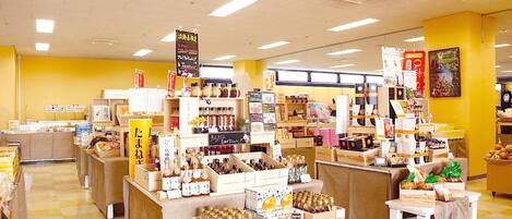 A store interior with shelves stocked with various products, including jars and boxes, and a counter area.