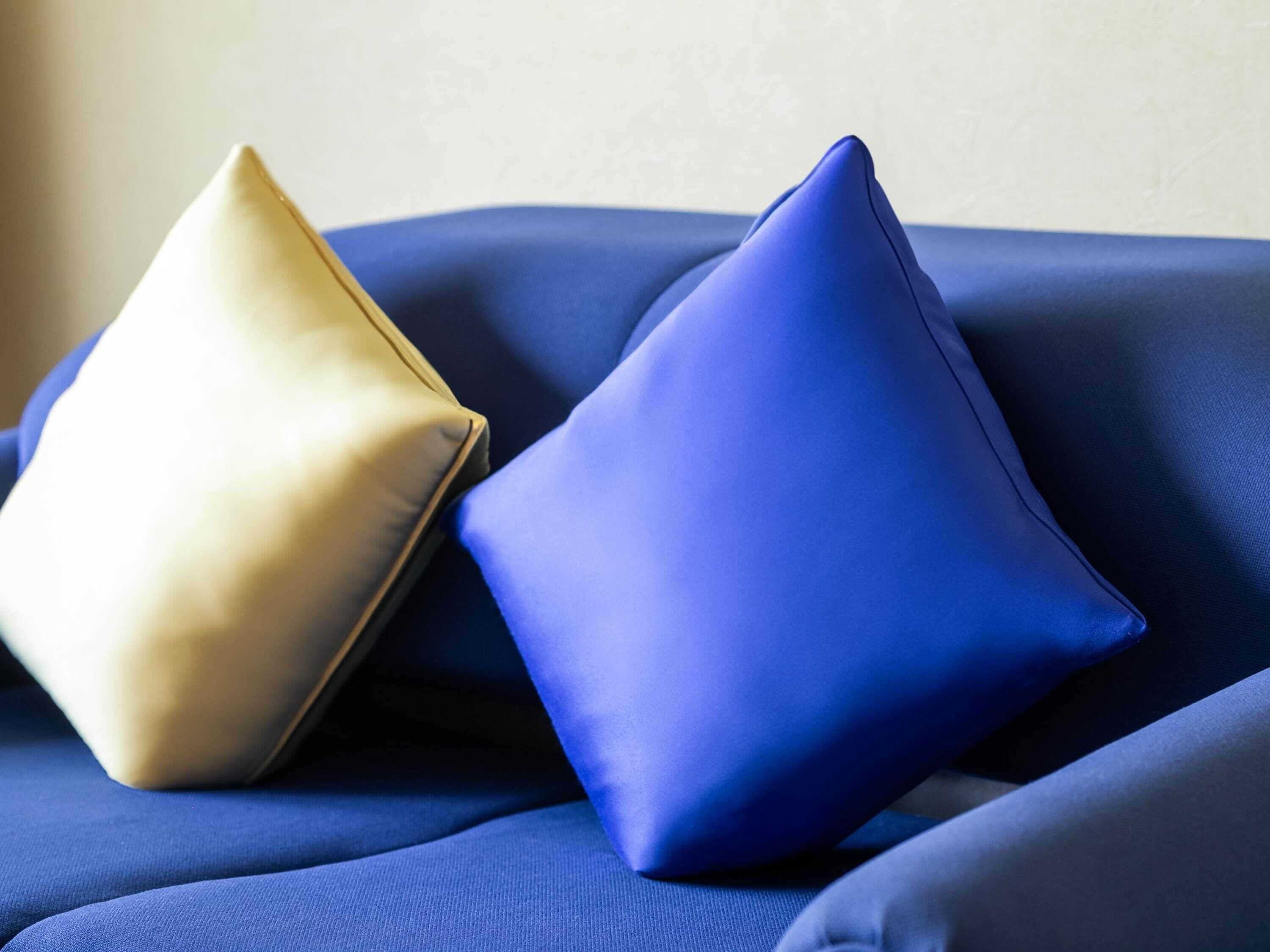 Dos almohadas sobre una superficie de tela azul.