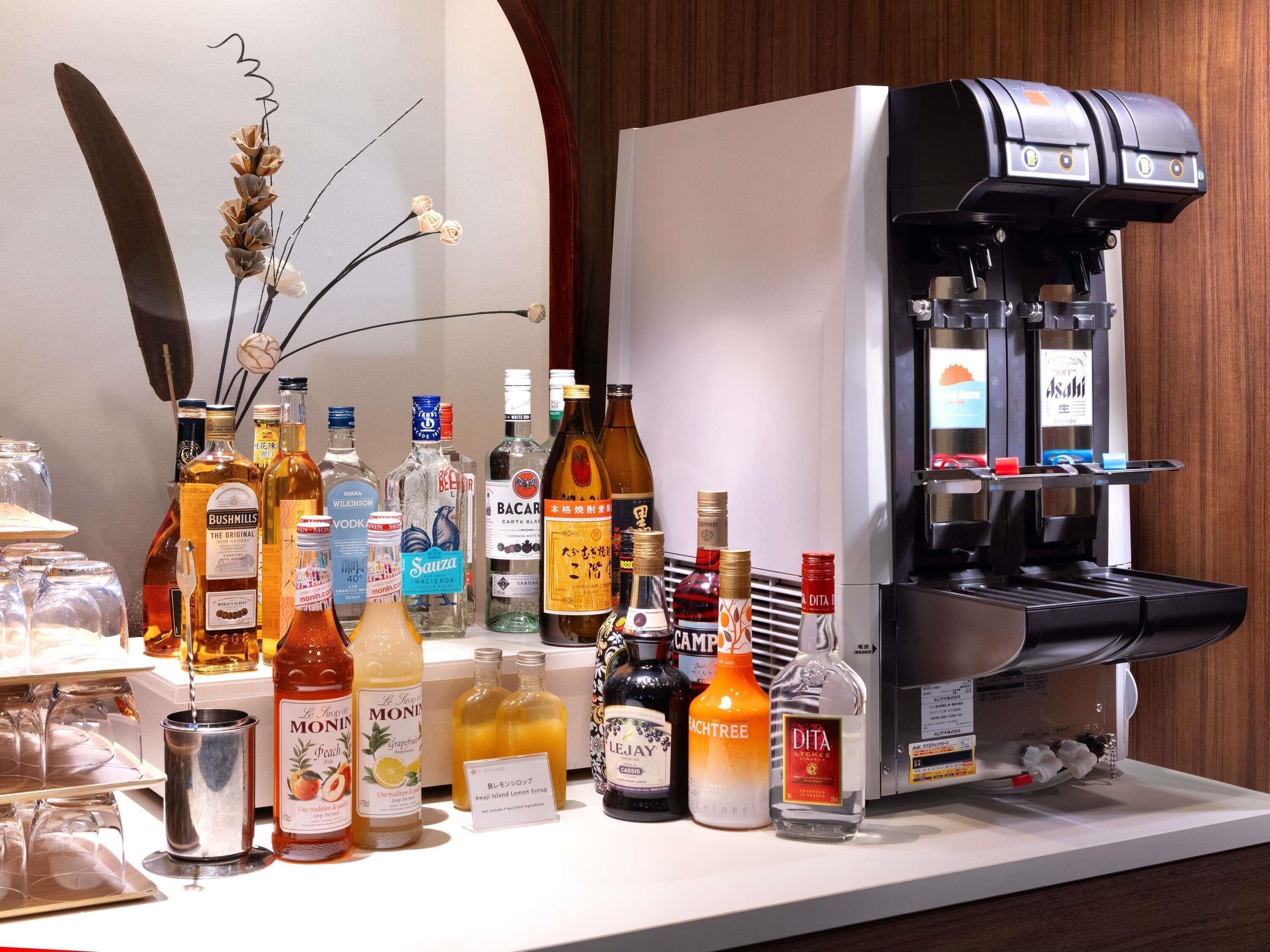 Eine Bar mit einer Kaffeemaschine und verschiedenen alkoholischen Getränken.