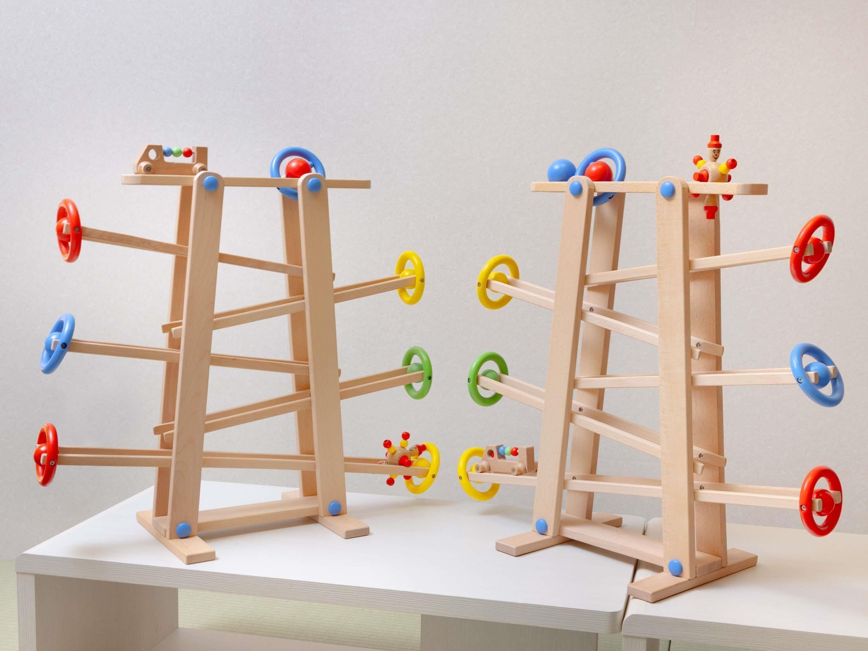 Dos estructuras de madera con varias ruedas y una figura pequeña en la parte superior.