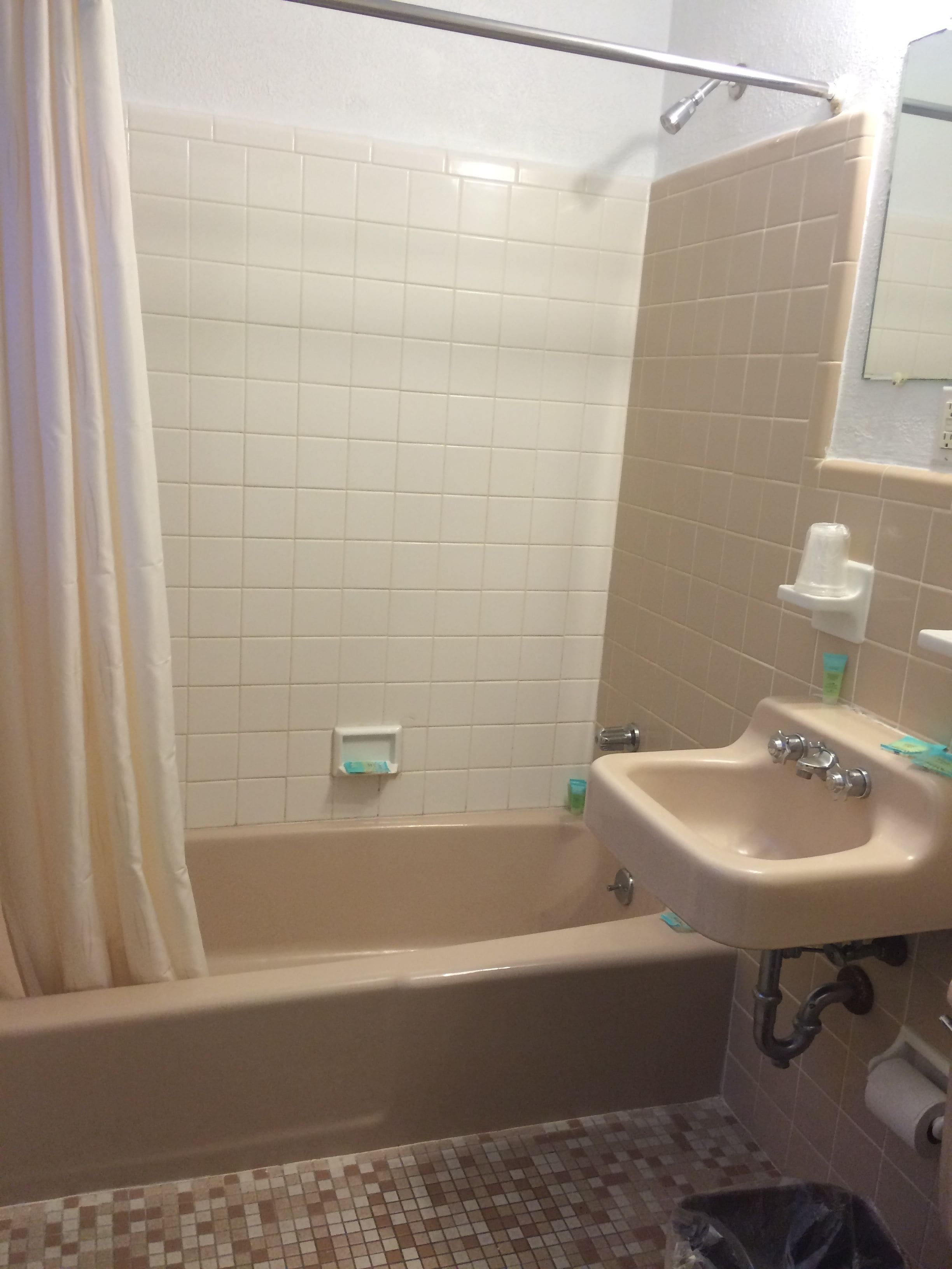 A bathroom with a bathtub, a sink, and a shower area.