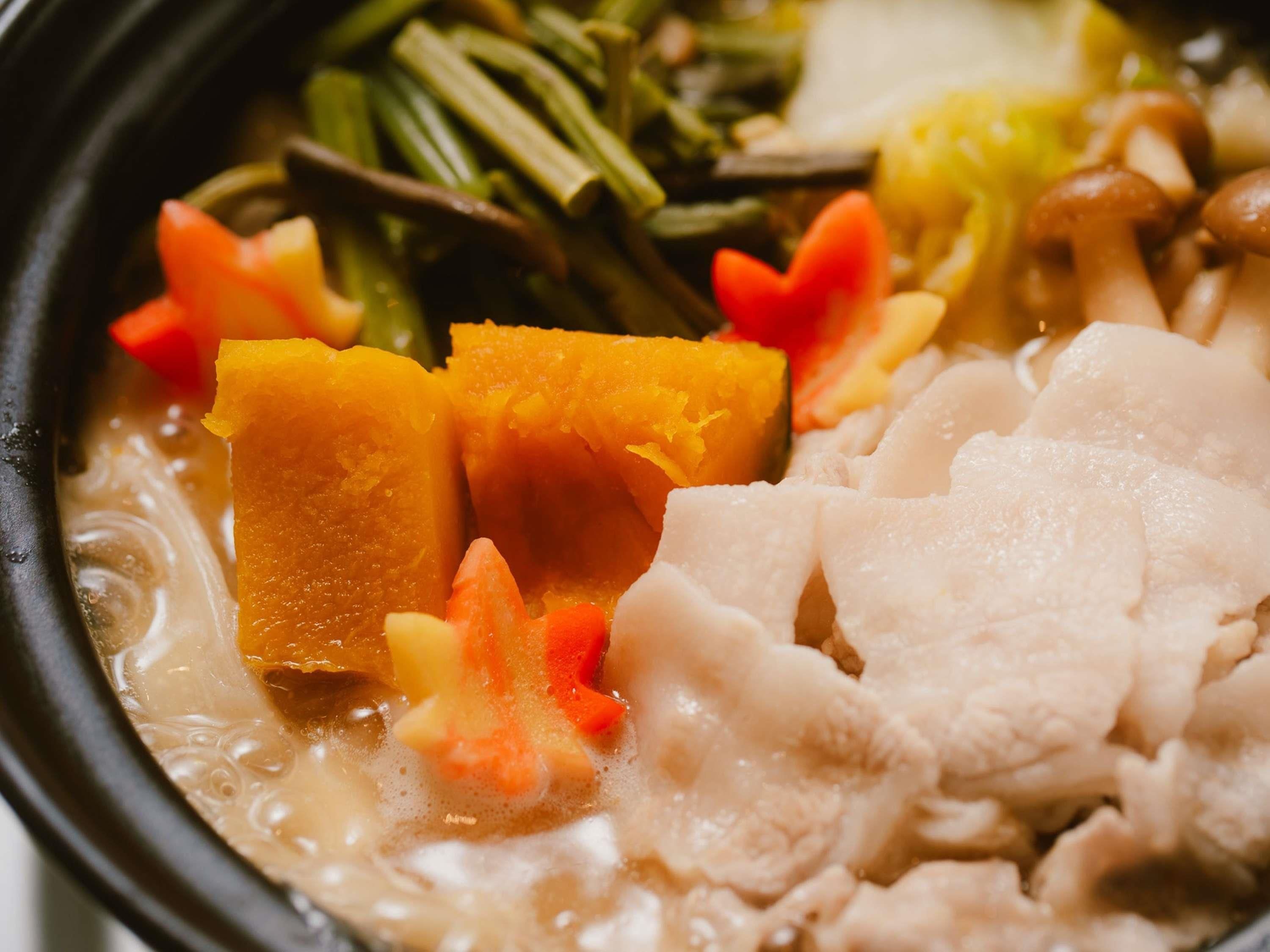 Un tazón de sopa con verduras y carne.