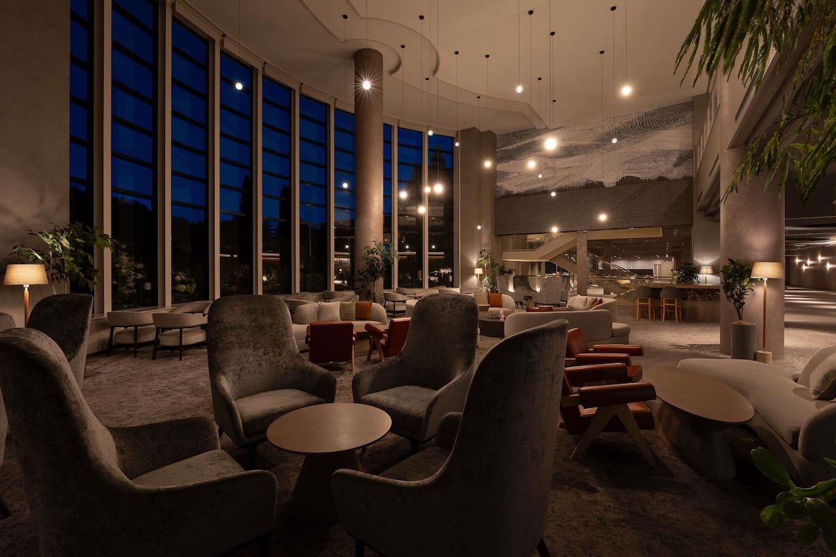 A spacious lobby with high ceilings, large windows, and modern seating arrangements.