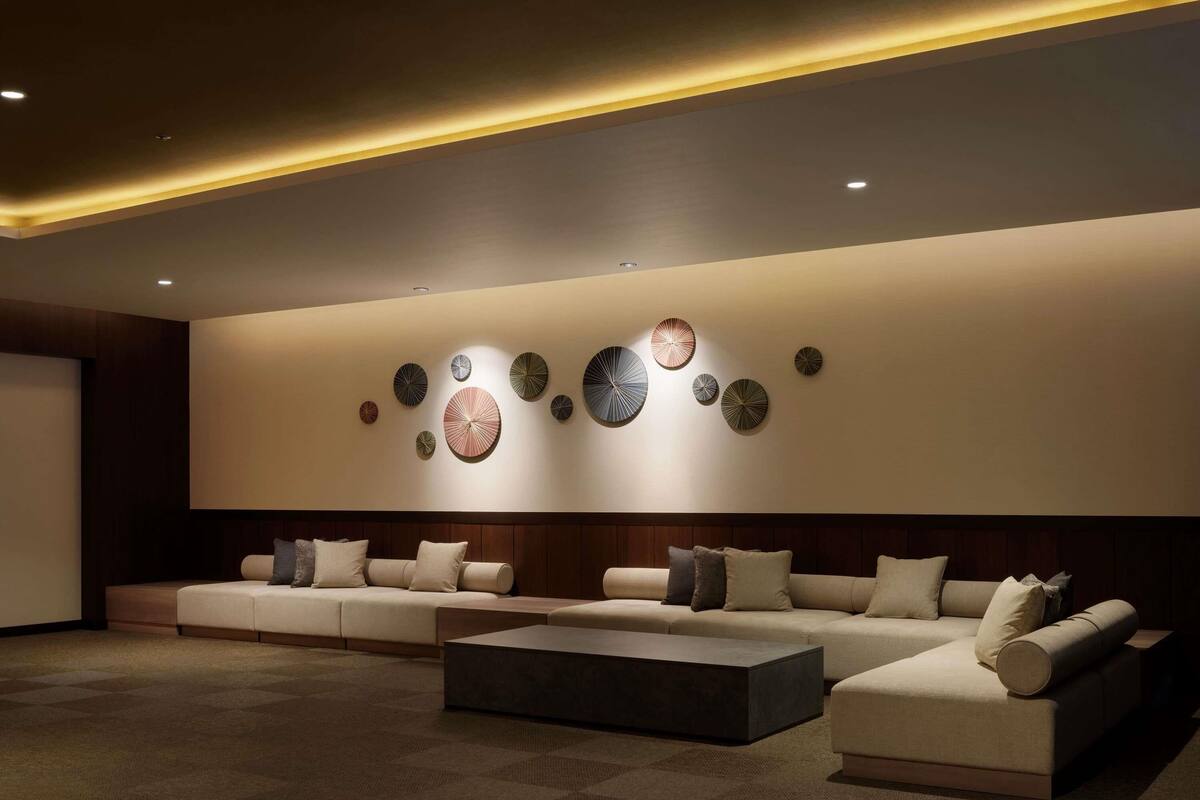 Una sala moderna con un amplio sofá modular, una mesa de centro y arte decorativo en la pared.