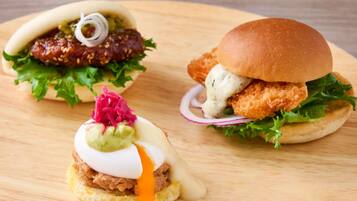 Tres hamburguesas sobre una tabla de madera.