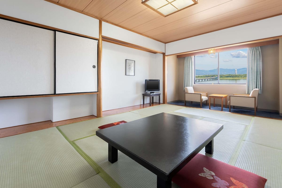 A traditional Japanese-style room with tatami flooring, a low table, and a television.
