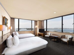 A hotel room with two beds, a TV, a desk, and a view of the water. - Grand Mercure Lake Hamana Resort & Spa (Hamamatsu)