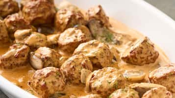 A dish of meatballs in creamy sauce.