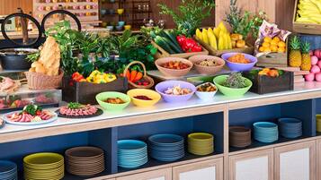 Un bufé con diversos alimentos y una variedad de recipientes y platos.