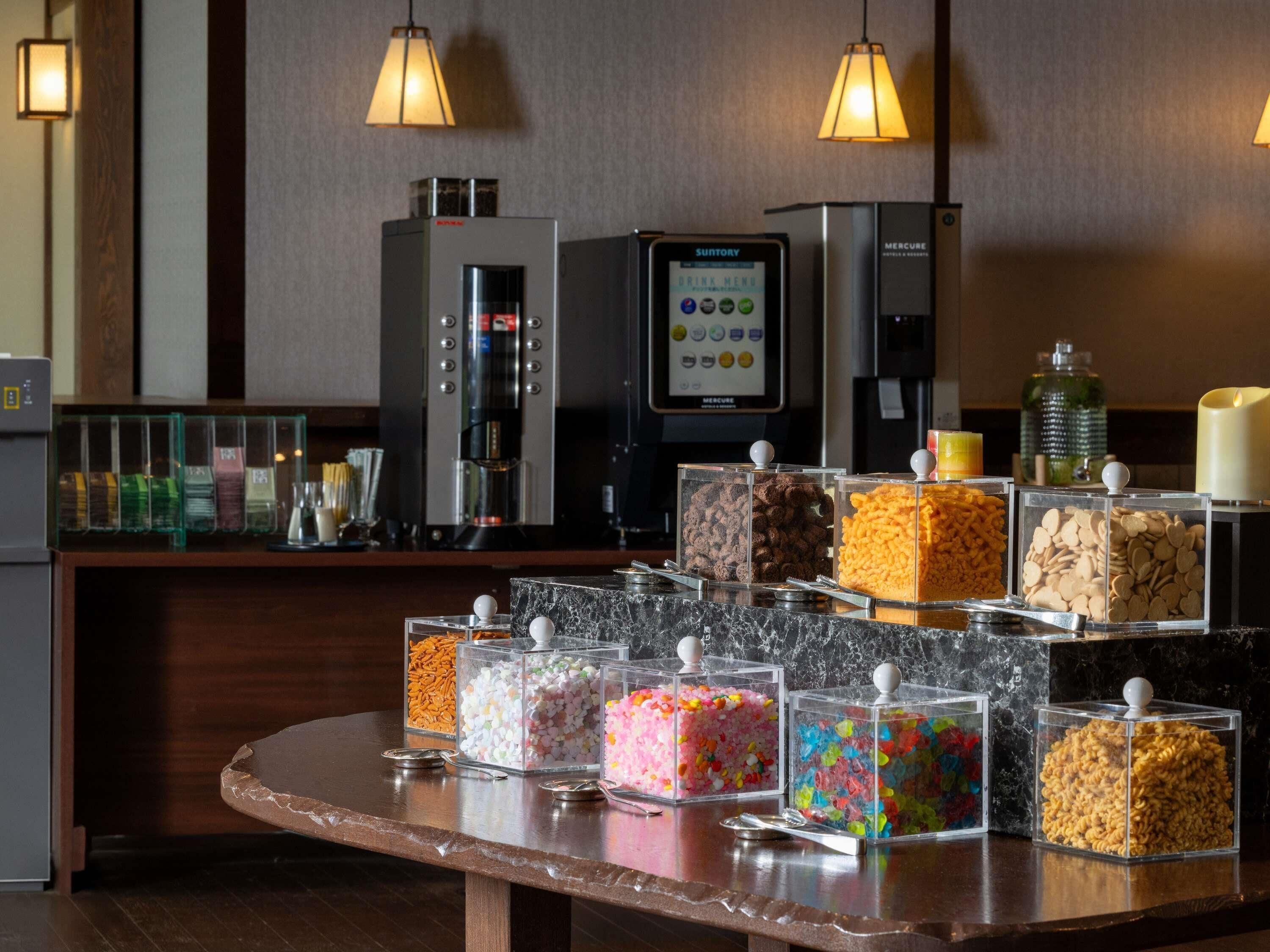 A self-service beverage station with a coffee machine and a drink menu display.