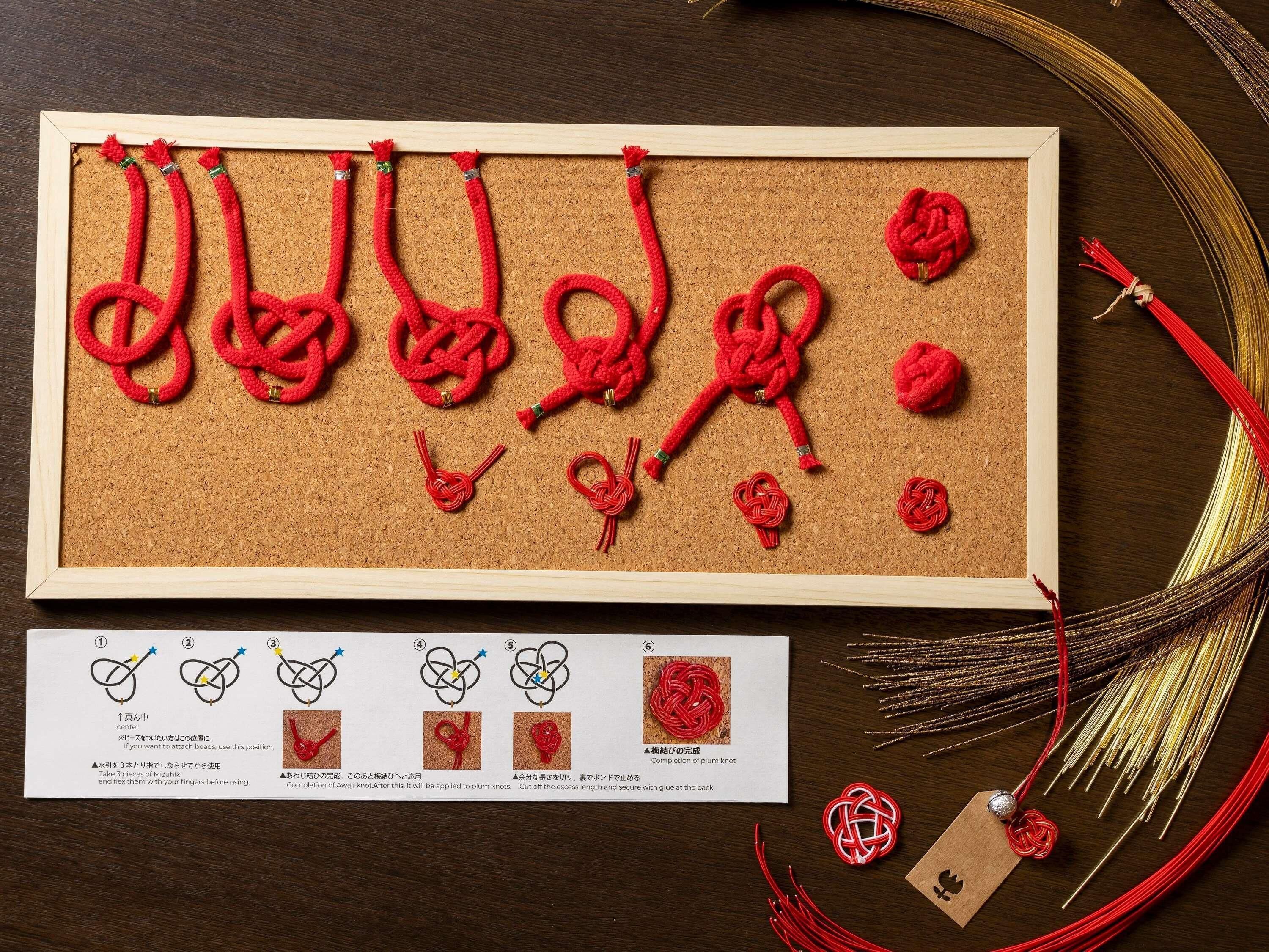 A corkboard with various red knots and a card with knot diagrams.